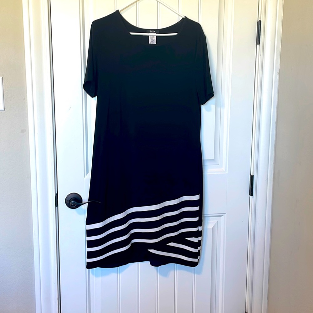 Black dress with asymmetrical trim on hem.